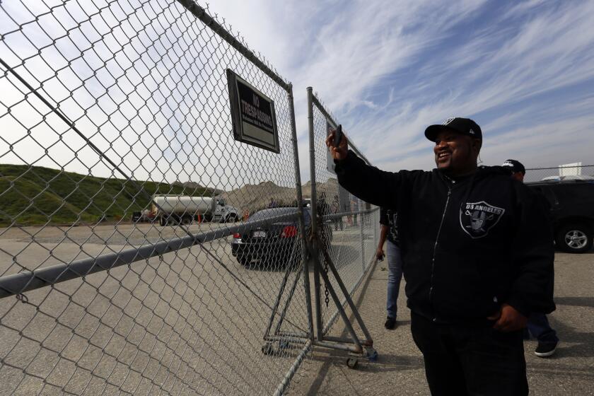 Raiders fan Tyrone Butterfield of Long Beach makes a video at the proposed sight of a new NFL stadium in Carson on Friday.
