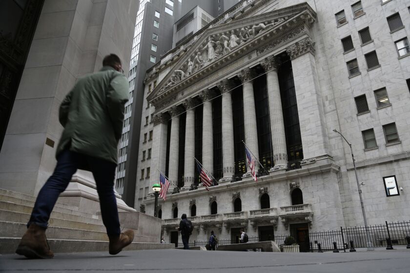 People pass the front of the New York Stock Exchange in New York, on Wednesday, March 22, 2023. European shares have opened mixed after a day of gains in Asia ahead of a decision by the Federal Reserve on interest rates. (AP Photo/Peter Morgan