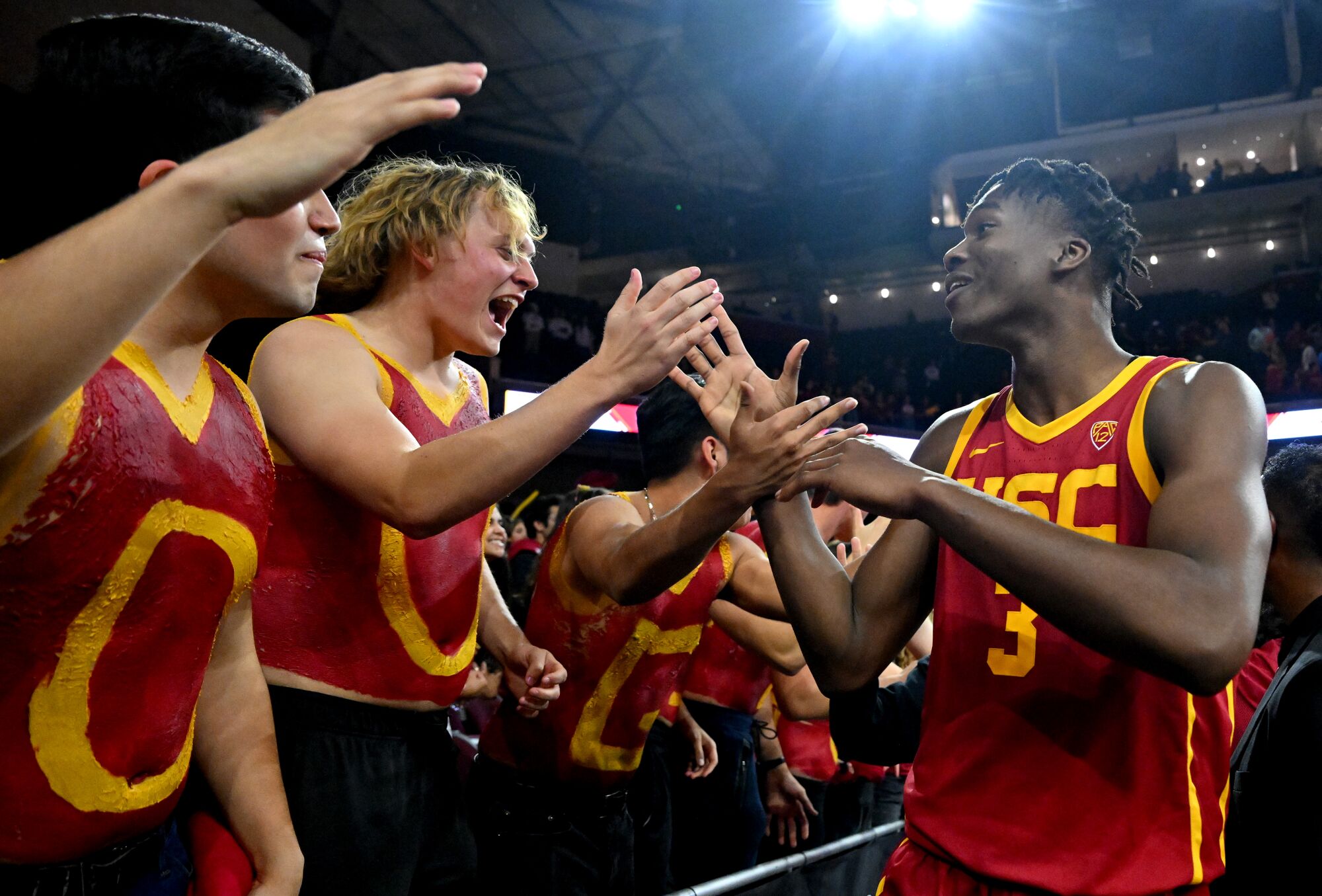 USC's Vincent Iwuchukwu high fives and celebrates with students after defeating UCLA 