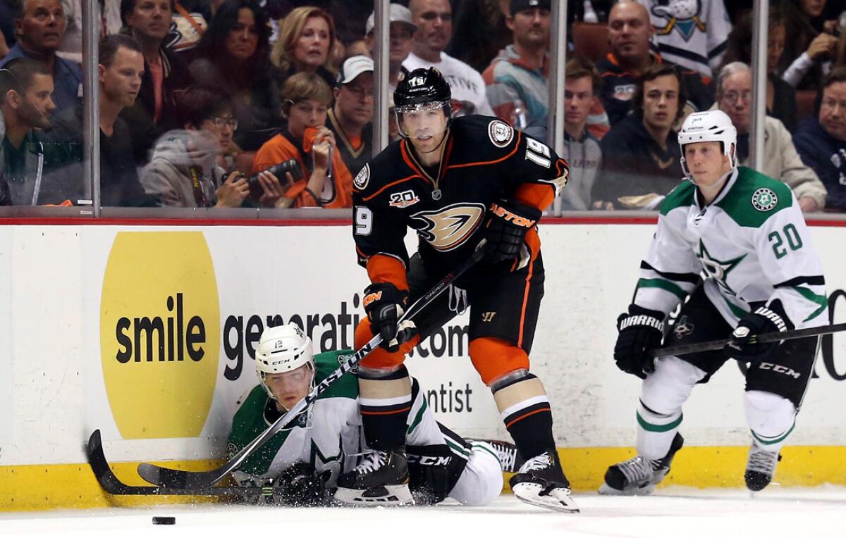 Ducks defenseman Stephane Robidas (19) clears the puck after battling the Stars' Alex Chiasson and Cody Eakin (20) in the third period of Game 2 on Friday night at Honda Center.