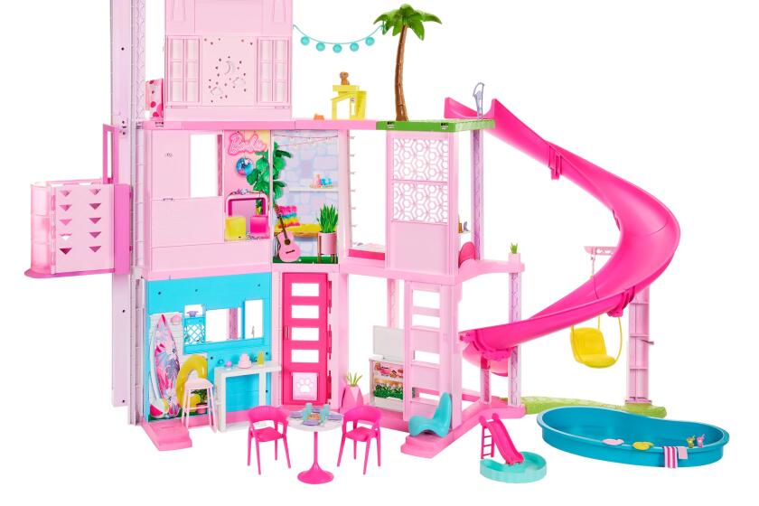 A three-tory contemporary-style dollhouse is rendered in pink with a bright slide, a palm tree and swimming pool