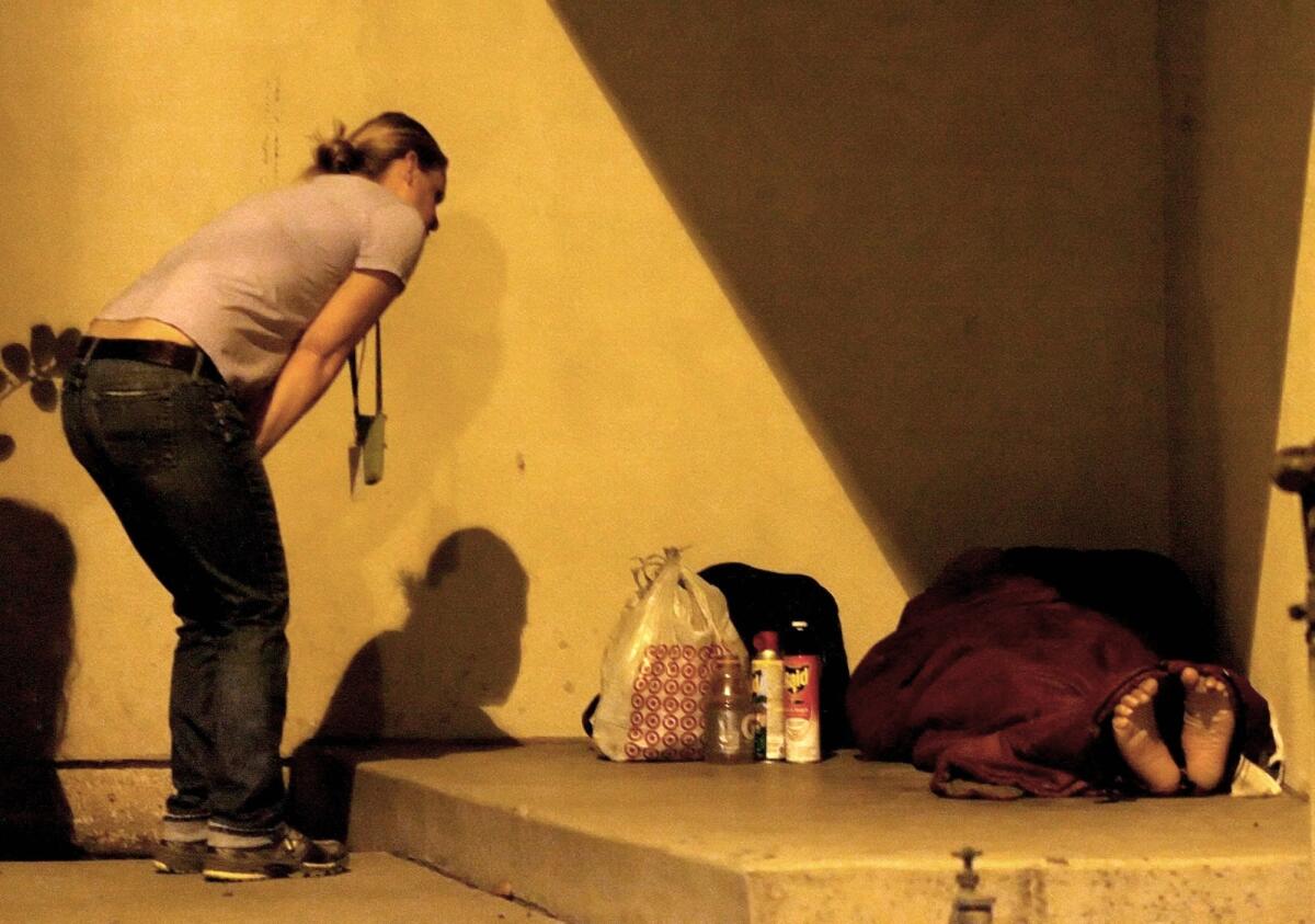 In this file photo from Aug. 9, 2011, Housing Works' Sieglinde von Dessner attempts to speak with Fernando Ruiz, who at the time had been homeless and living on the streets of Pasadena for five years.