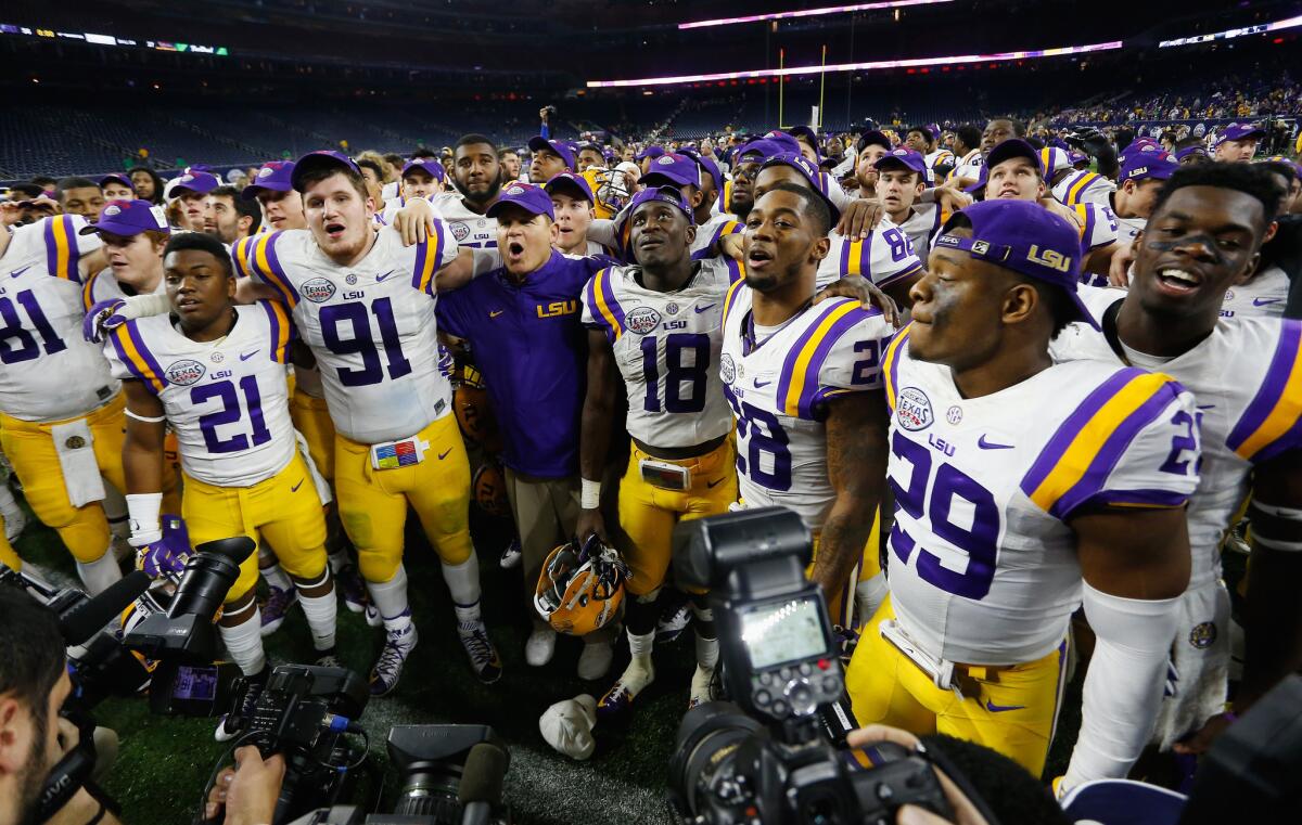 LSU head coach Les Miles, center, celebrates with this team after defeating Texas Tech in the Texas Bowl on Dec. 30.