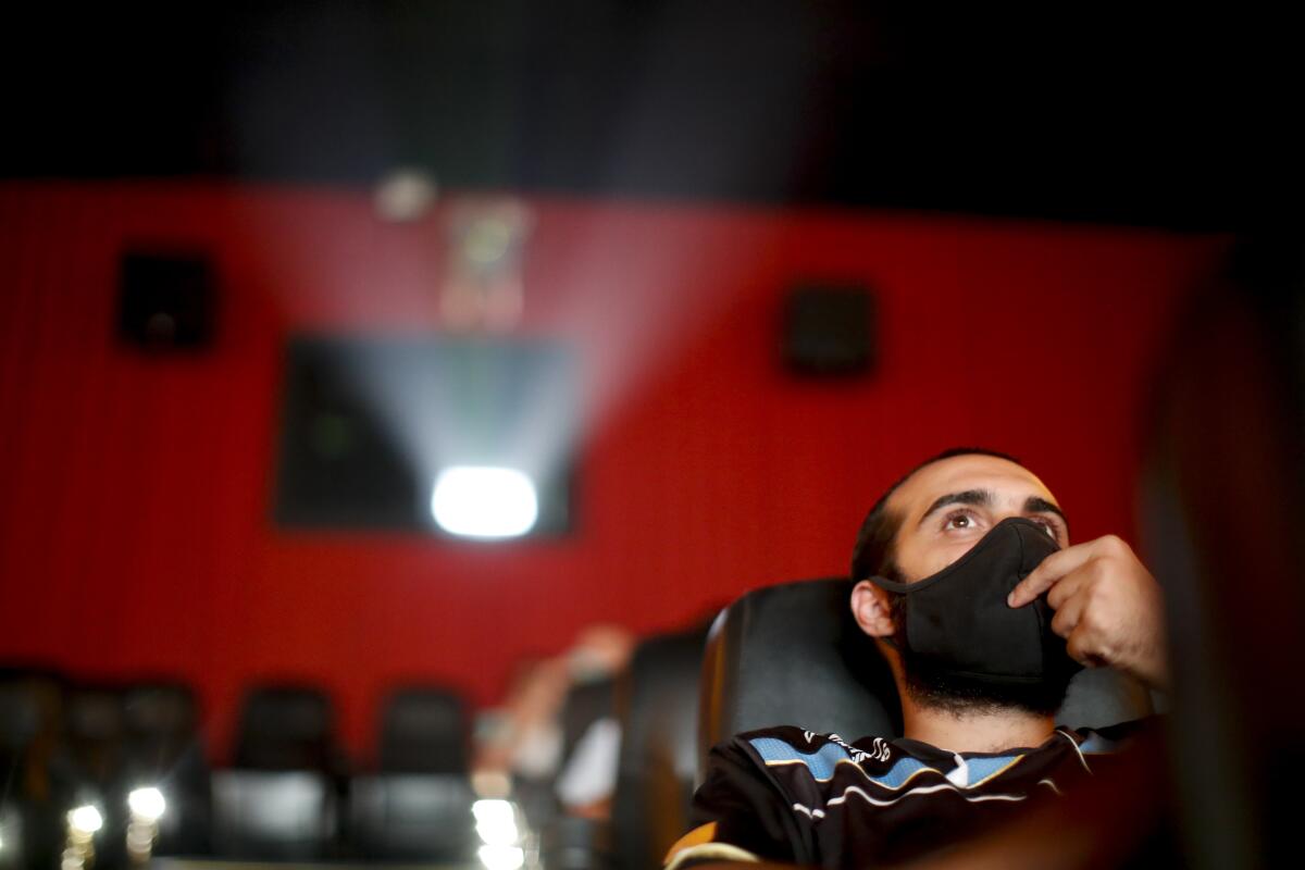 A man watches a movie at a cinema after almost a year of theaters being closed due to the COVID-19 pandemic, in Buenos Aires, Argentina, Wednesday, March 3, 2021. (AP Photo/Natacha Pisarenko)
