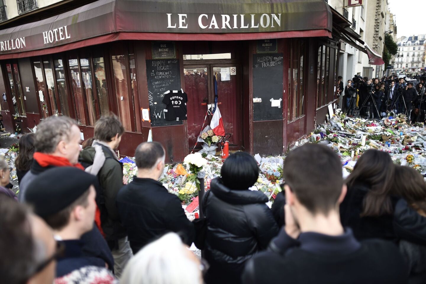 People observe a minute of silence in front of the Le Carillon cafe in Paris on Nov. 16, paying tribute to victims of the terror attacks.