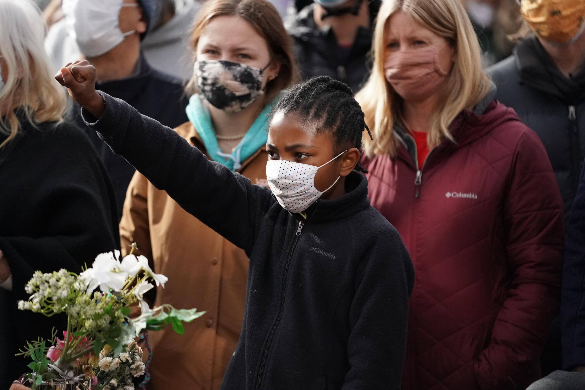 A young girl raises her fist 