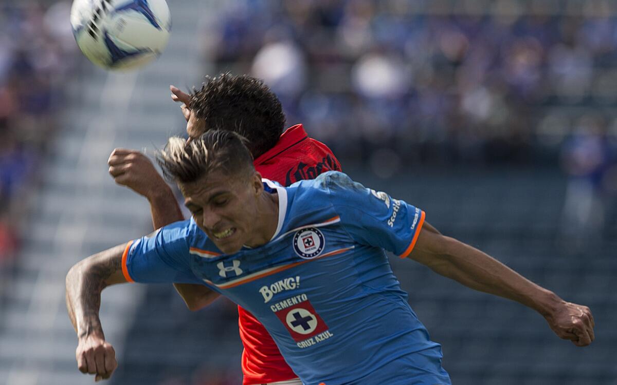 Richard Ruiz, de Cruz Azul, pelea un balón con José Olvera, del Morelia.