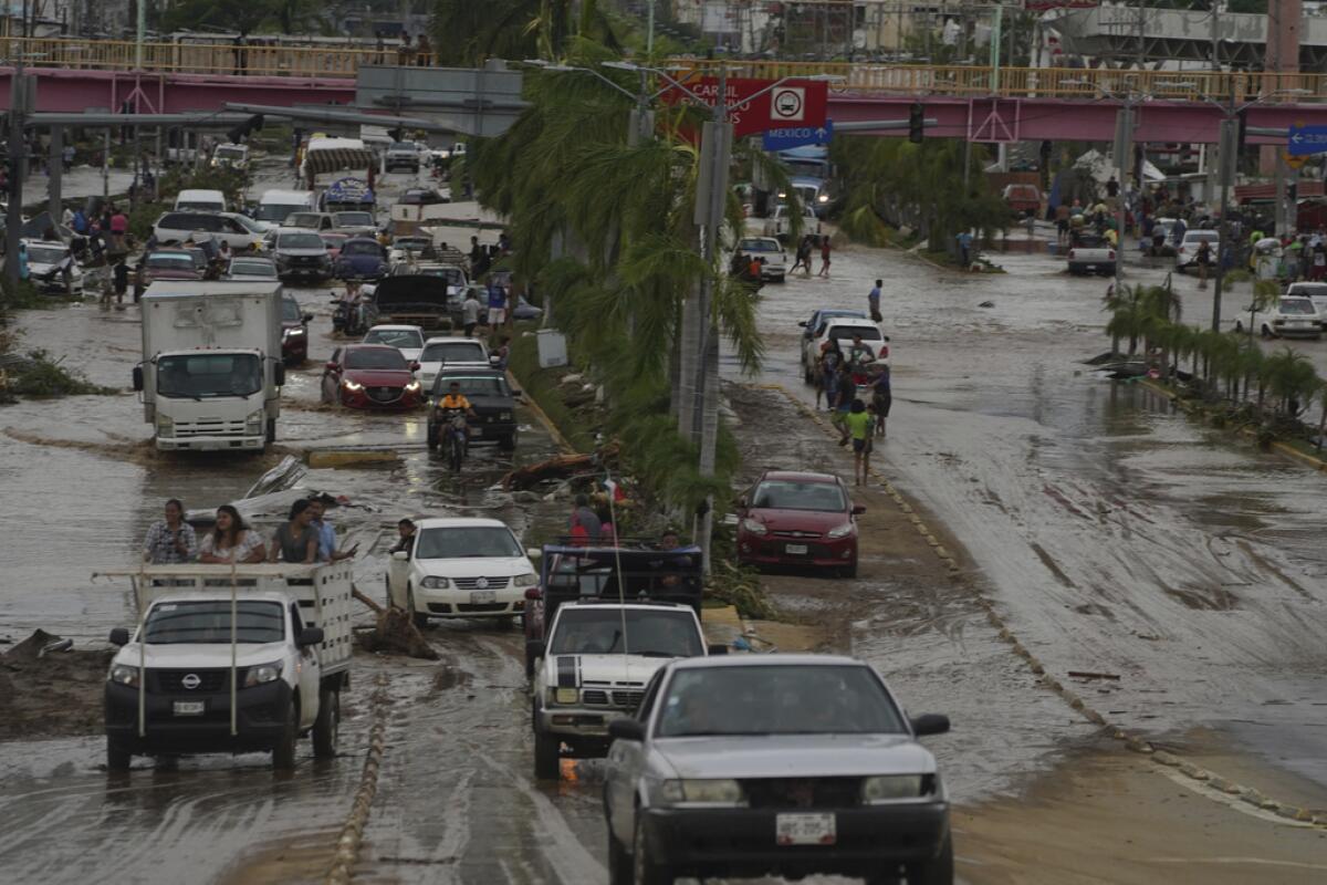 Autos cruzan una avenida anegada tras el paso del huracán