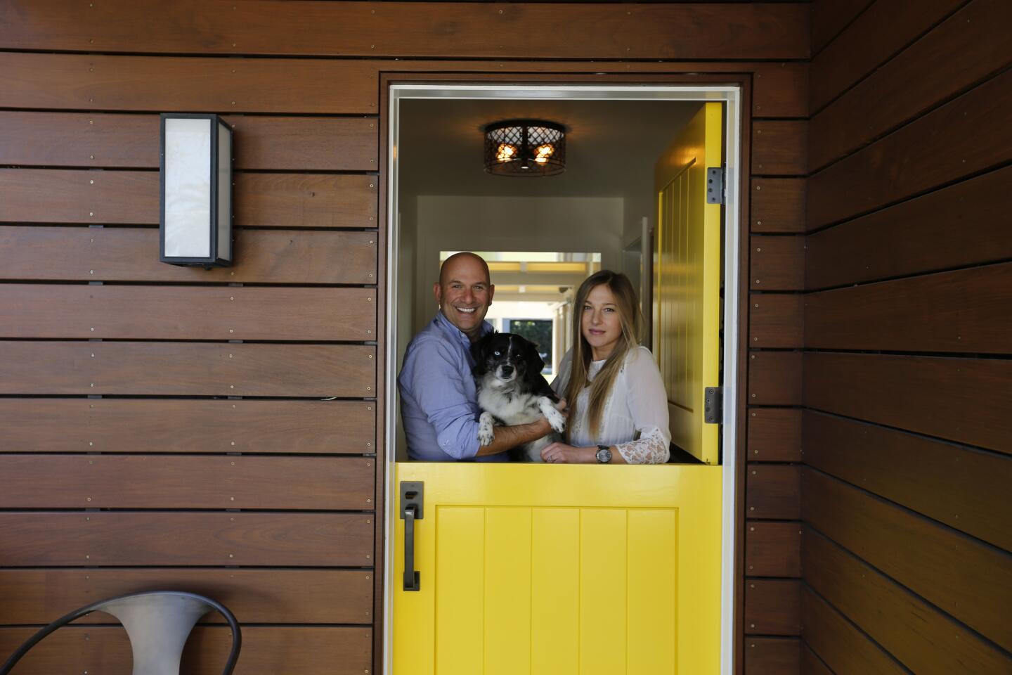 Drybar co-founder Michael Landau, his wife Sarah Hutnick and dog Samson at the entrance to their newly remodeled Costa Mesa ranch house.