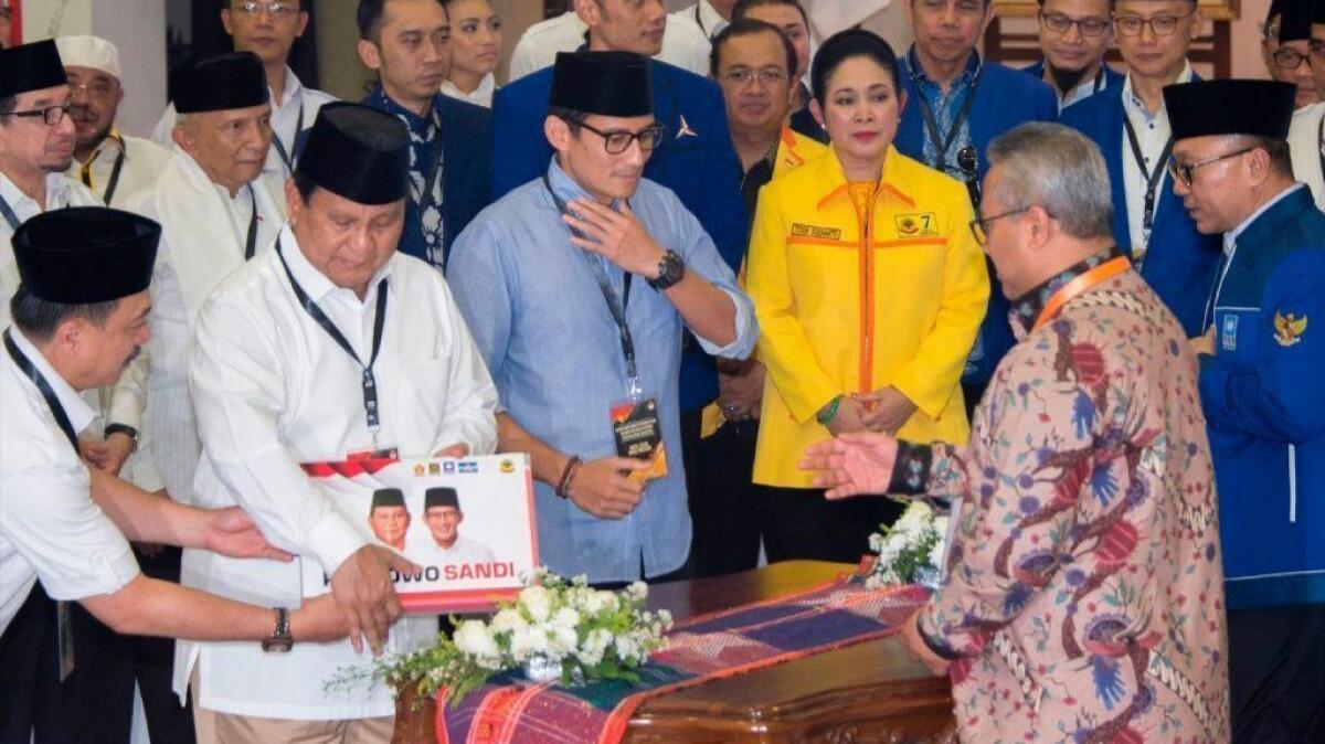 Retired general Prabowo Subianto, second from left, and his running mate, Sandiaga Uno, in blue shirt, register as candidates for the 2019 Indonesian presidential election on Aug. 10.