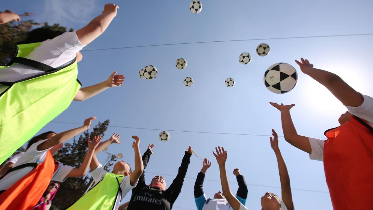 Palestinian children attend a soccer training session given by the Spanish club Real Madrid in the West Bank city of Ramallah on March 23, 2015, as part of a project organized through the United Nations Palestinian refugee agency UNRWA.