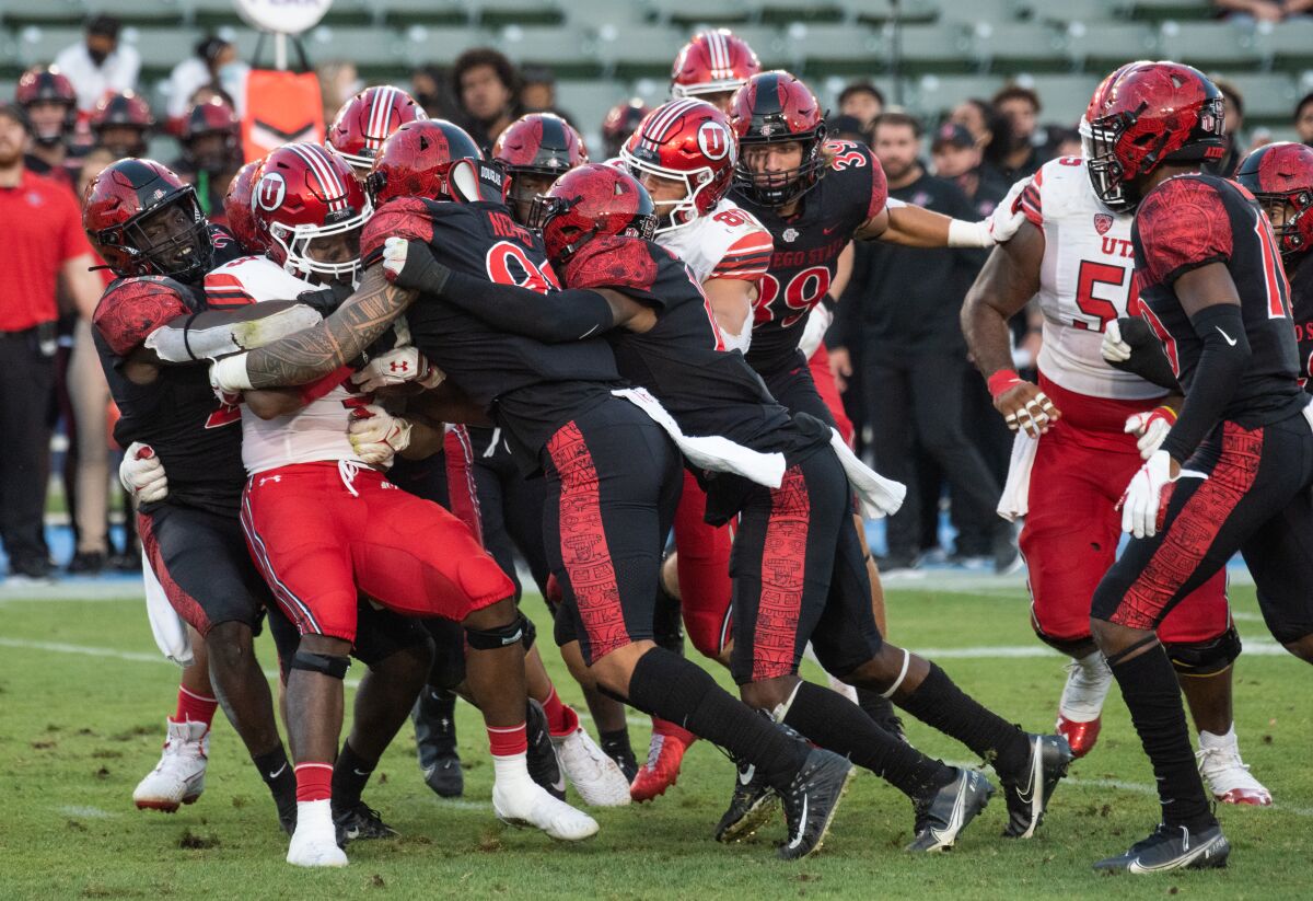 Aztecs defenders swarm Utah's Vonte Davis during a Sept. 18 win at Dignity Health Sports Park in Carson.