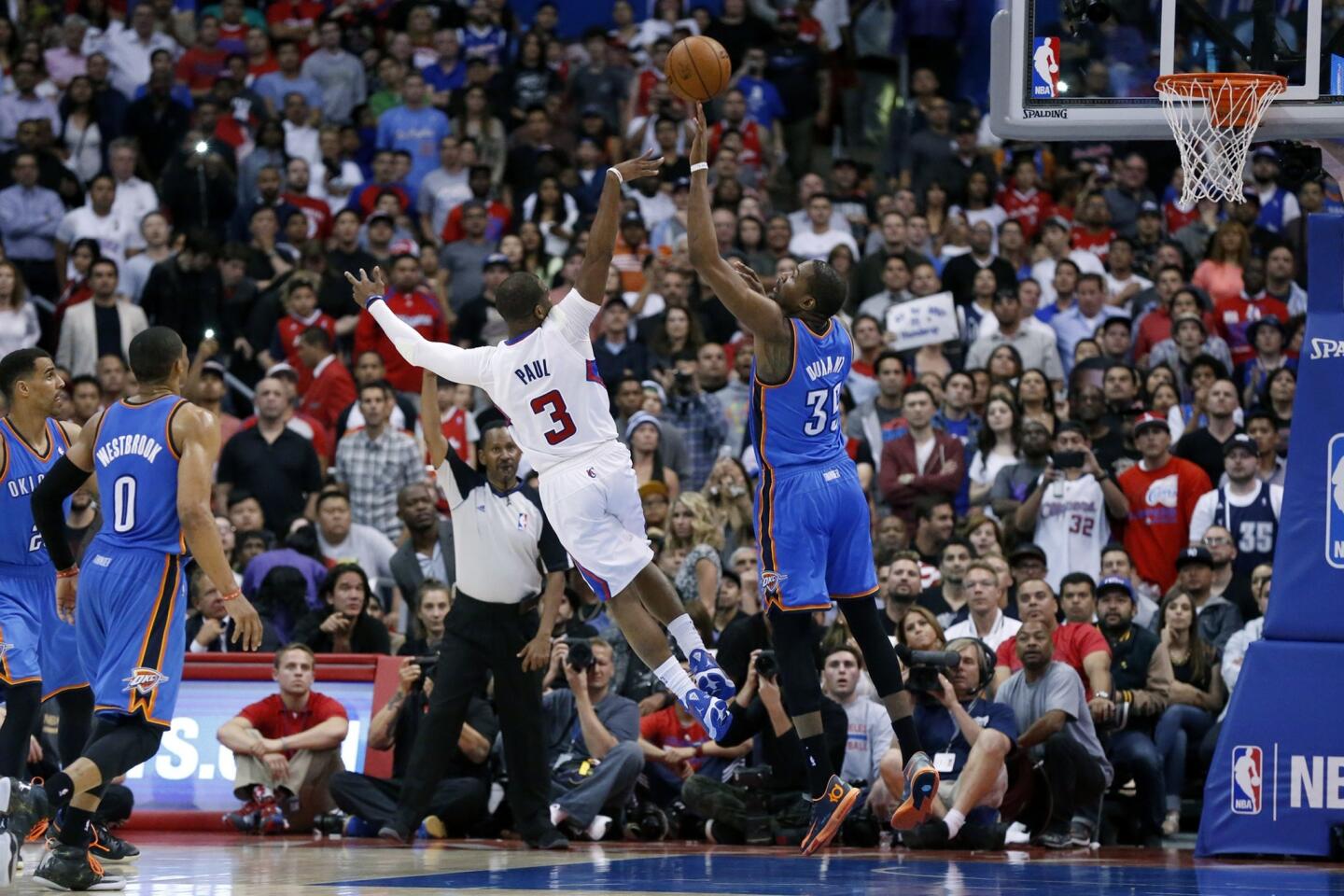 Clippers point guard Chris Paul, left, shoots over Oklahoma City Thunder small forward Kevin Durant late in the fourth quarter of the Clippers' 107-101 loss Wednesday at Staples Center.