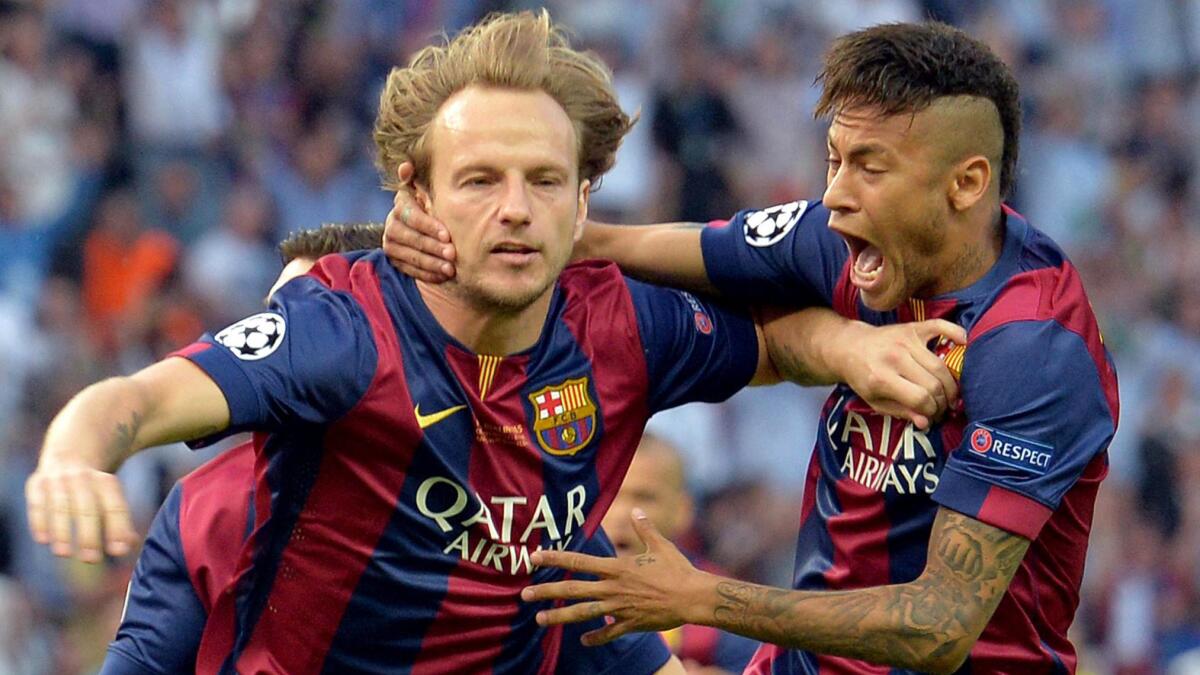FC Barcelona's Ivan Rakitic, left, celebrates with teammate Neymar after scoring the match's first goal in 3-1 victory over Juventus for the UEFA Champions League title in Berlin on Saturday.