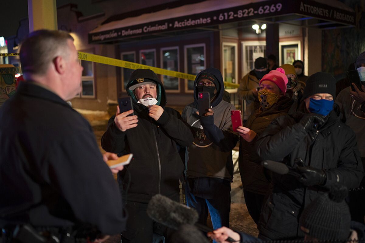 John Elder, left, a Minneapolis police spokesman, peaks with community members 