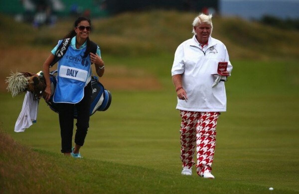 John Daly and his now-fiancee Anna Cladakis walk down the fairway during the British Open.