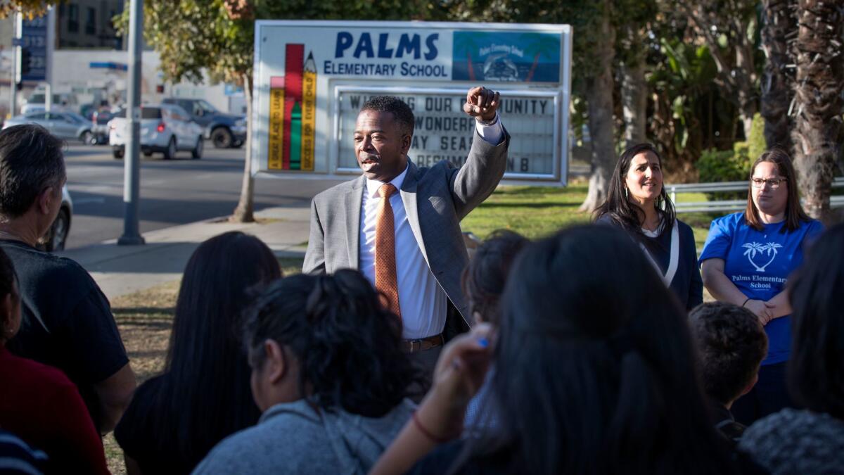 Olu K. Orange, center, an attorney representing teachers and students, announces a lawsuit Friday to prevent a construction project adjacent to Palms Elementary School.