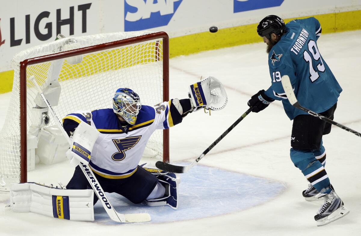 Blues goalie Jake Allen deflects a shot next to Sharks center Joe Thornton (19) during the third period of Game 4 on Saturday.