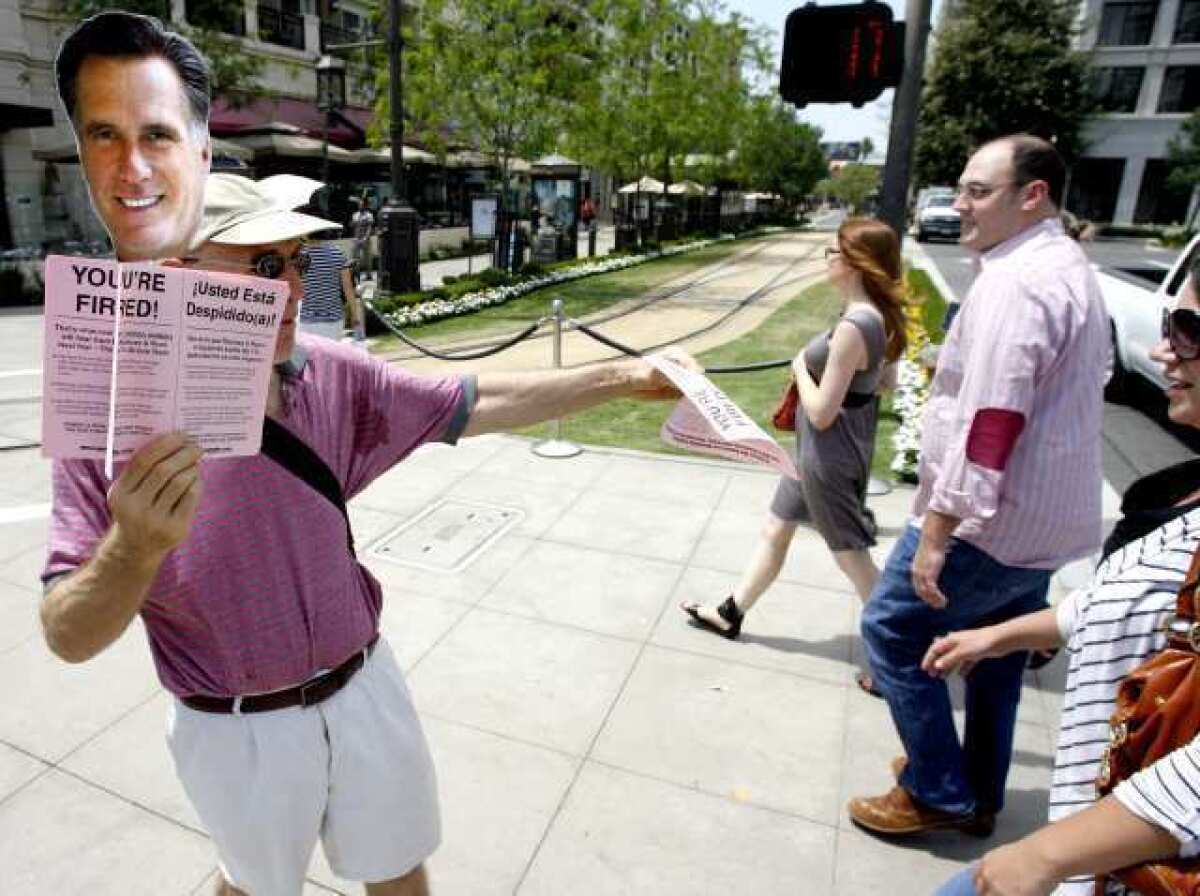 Mark S. of Moveon.org passes out "You're Fired" pamphlets to passersby at the Americana at Brand in Glendale. About 10 protesters were at both entrances to the outdoor shopping venue.