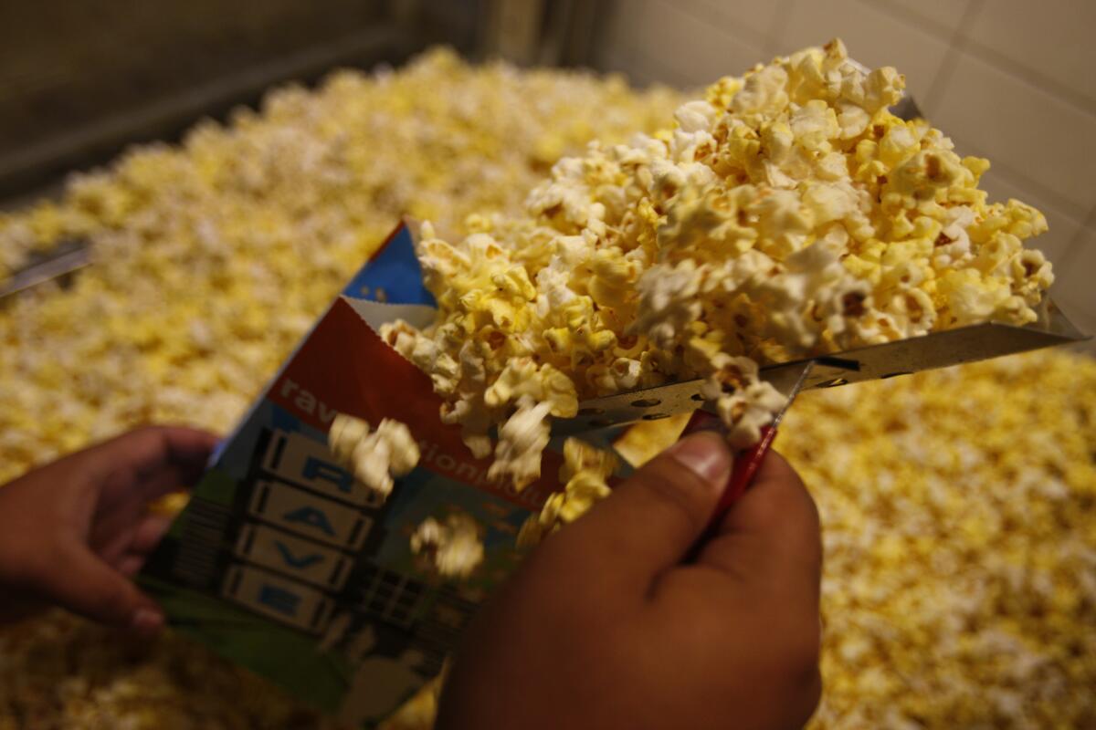 A concession worker scoops up popcorn