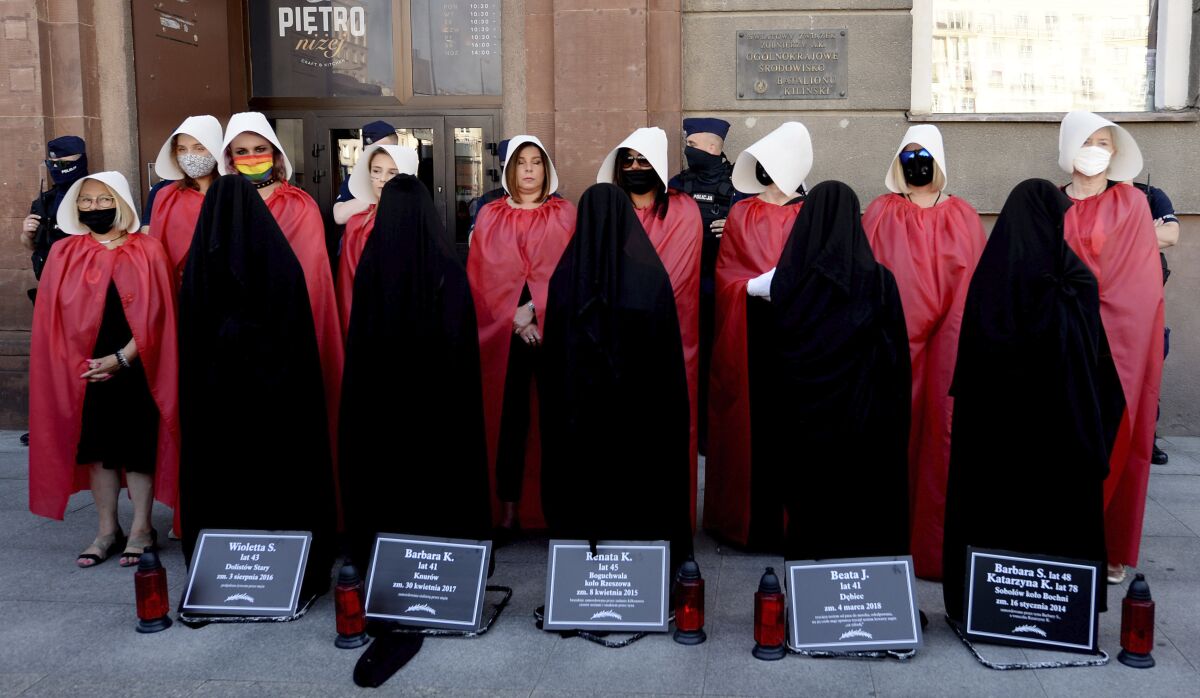 File-In this file photo from July 24, 2020, women dressed to evoke the feminist dystopian story "The Handmaid's Tale" carry out a symbolic protest after a government minister threatened to pull the country out of an international convention aimed at protecting women from violence, including domestic violence. The treaty is known as the Istanbul Convention and is the work of the Council of Europe, an intergovernmental human rights body. A delegation from the organization has been in Poland this week to assess Poland's adherence to the treaty. (AP Photo/Czarek Sokolowski/file)