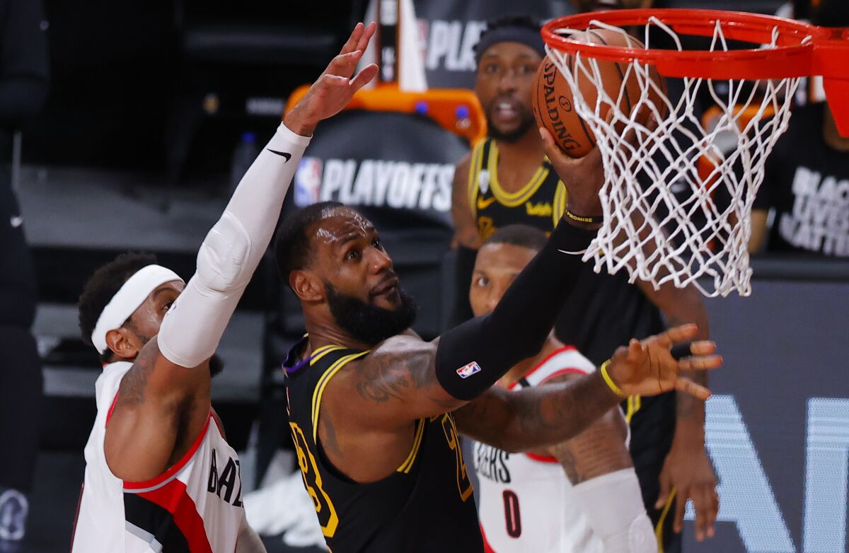 Lakers forward LeBron James shoots in front of Portland Trail Blazers forward Carmelo Anthony.