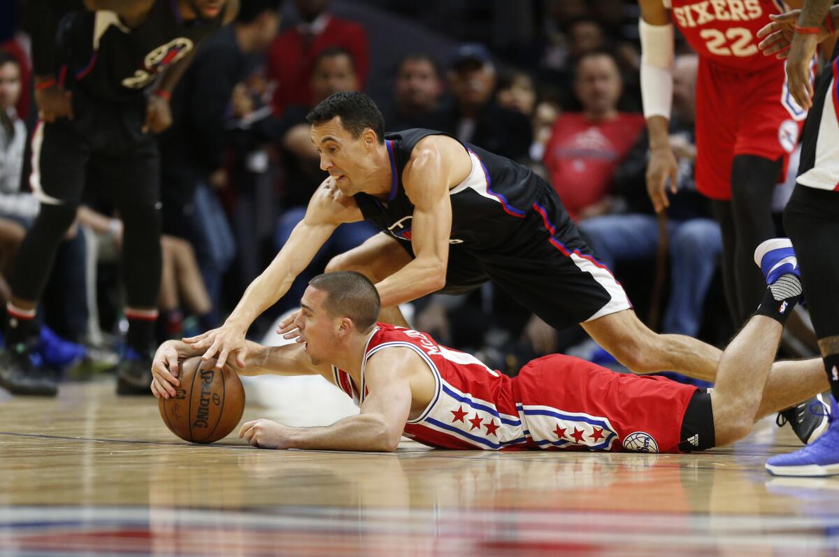 Clippers guard Pablo Prigioni (9) battles on the ground with 76ers guard T.J. McConnell (12) for a loose ball in the second half.