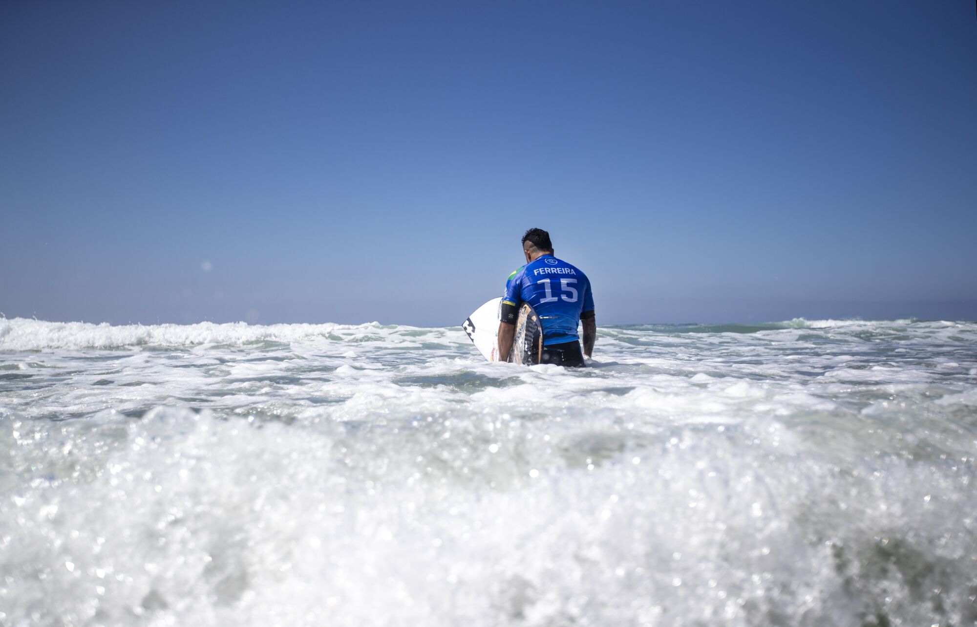 Italo Ferreira stands alone in the ocean after losing to Filipe Toledo