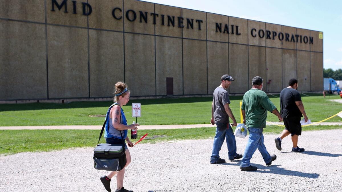 Workers leave the Mid Continent Nail Corp. after their shift.