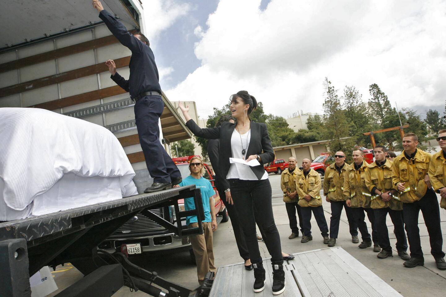 Actress Emmanuelle Chriqui and LA County Capt. Pat Sprengel unveil a truck full of new mattresses being donated by the Westin Hotels to the firefighters of LA County Fire Camp 2 on Monday, April 15, 2013.