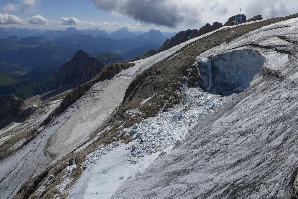 A view taken from a rescue helicopter of the Punta Rocca glacier near Canazei, in the Italian Alps in northern Italy, Tuesday, July 5, 2022, two days after a huge chunk of the glacier broke loose, sending an avalanche of ice, snow, and rocks onto hikers. Italy was enduring a prolonged heat wave before a massive piece of the Alpine glacier broke off and killed hikers on Sunday and experts say climate change will make those hot, destabilizing conditions more common. (AP Photo/Luca Bruno)