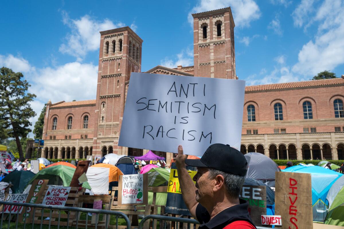 Phillip Schatkowski carries a pro-Israel sign outside a pro-Palestinian encampment at UCLA. 