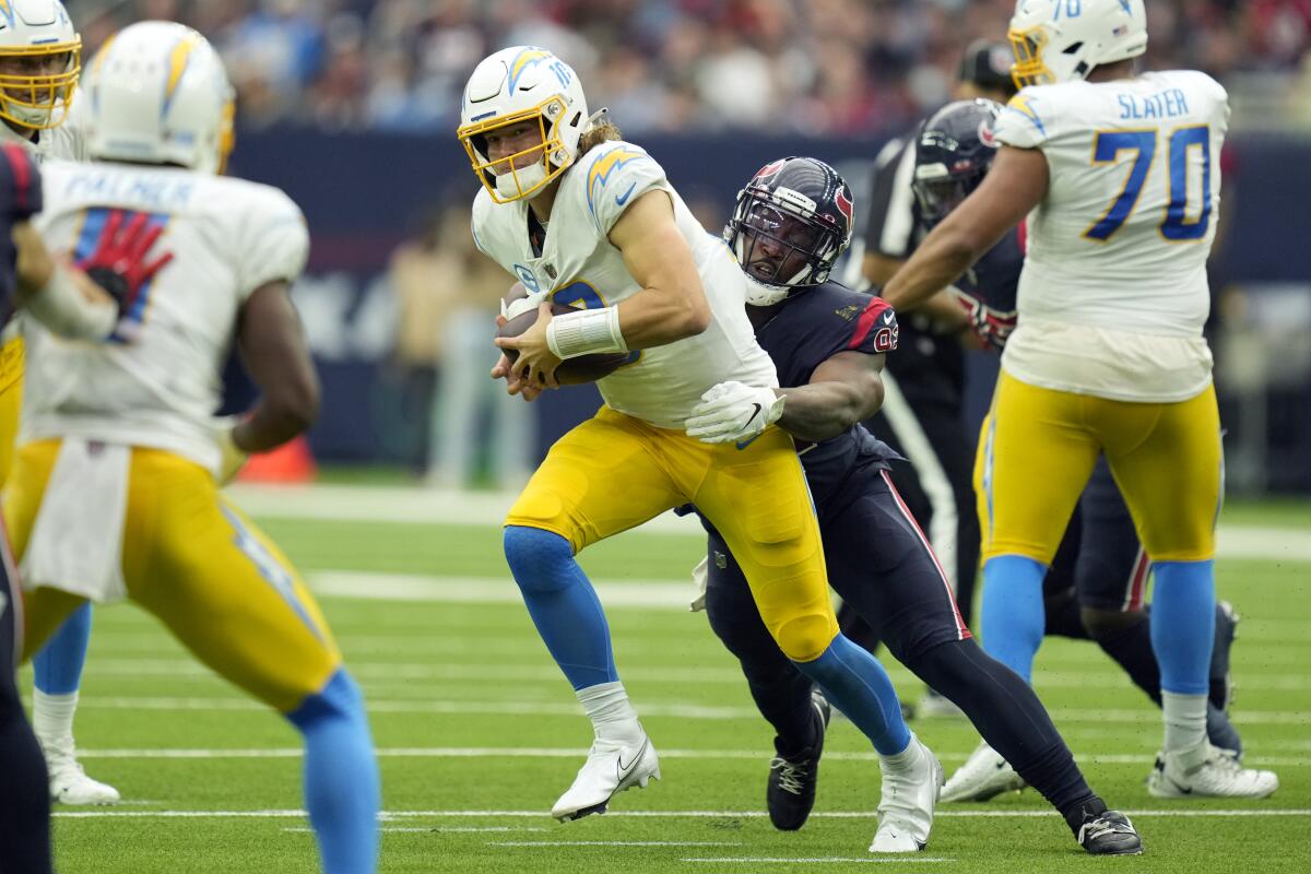 The Chargers' Justin Herbert (10) is sacked by Houston Texans' Chris Smith in the second half.