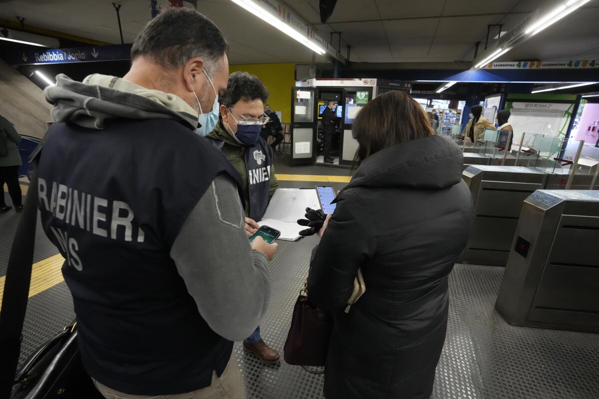 Police check the green health pass of public transportation passengers in Rome.