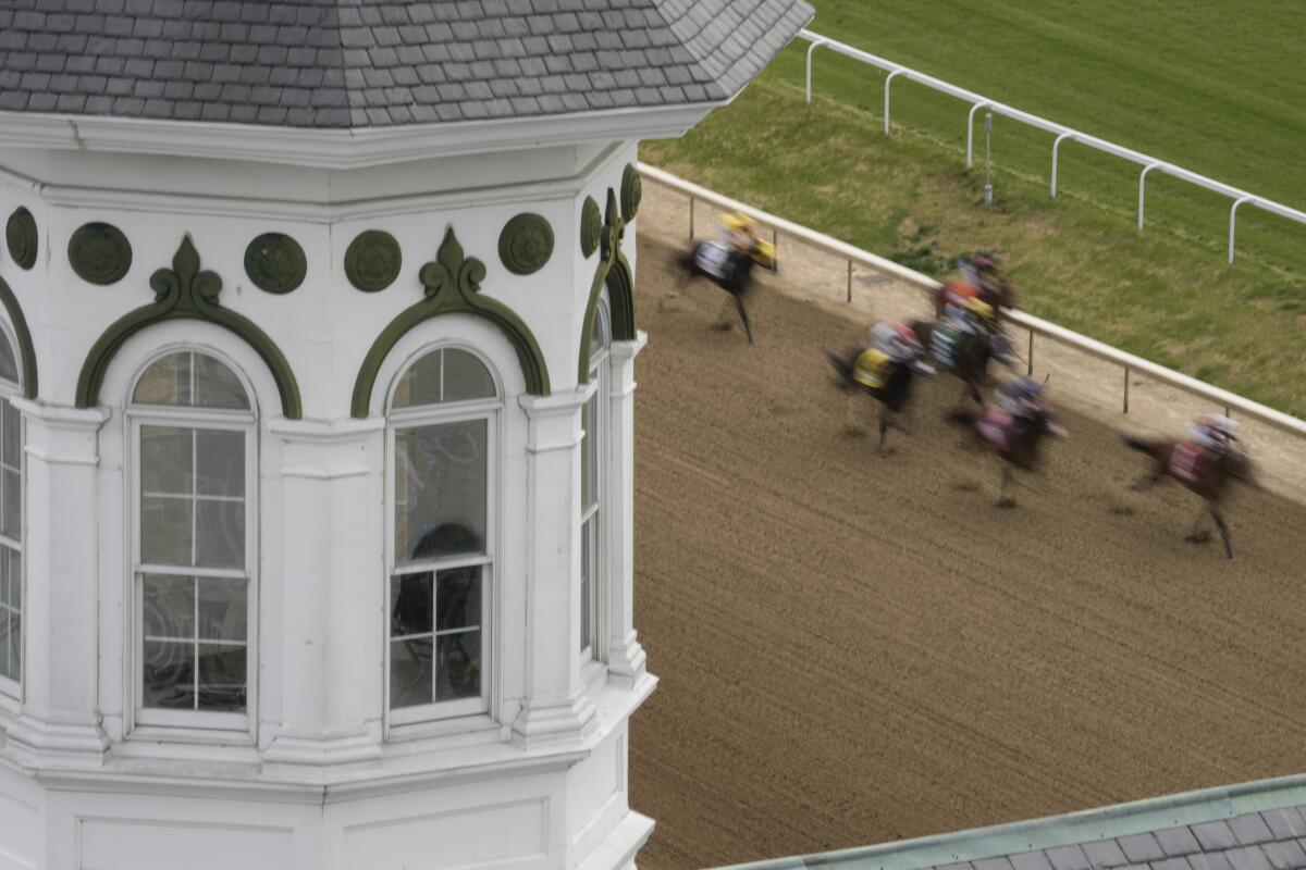 Horses run on a dry track during the first race at Churchill Downs.