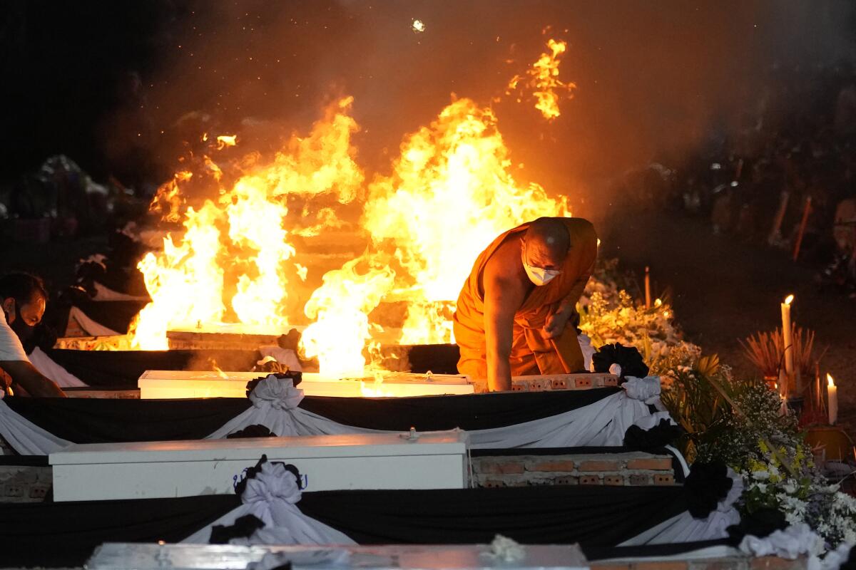 Monk lighting funeral pyres