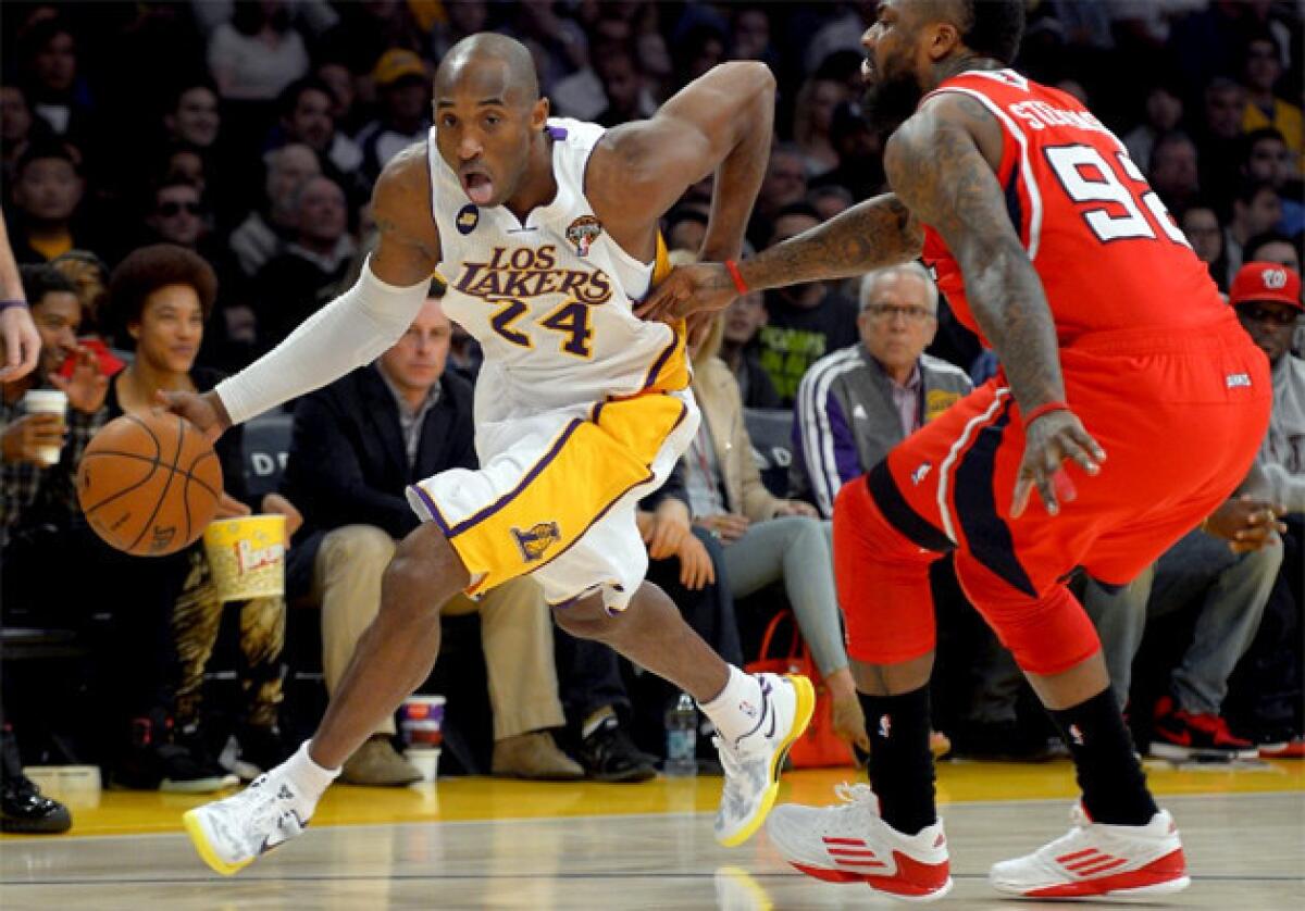Lakers guard Kobe Bryant, left, drives toward the basket as Atlanta Hawks' DeShawn Stevenson defends.