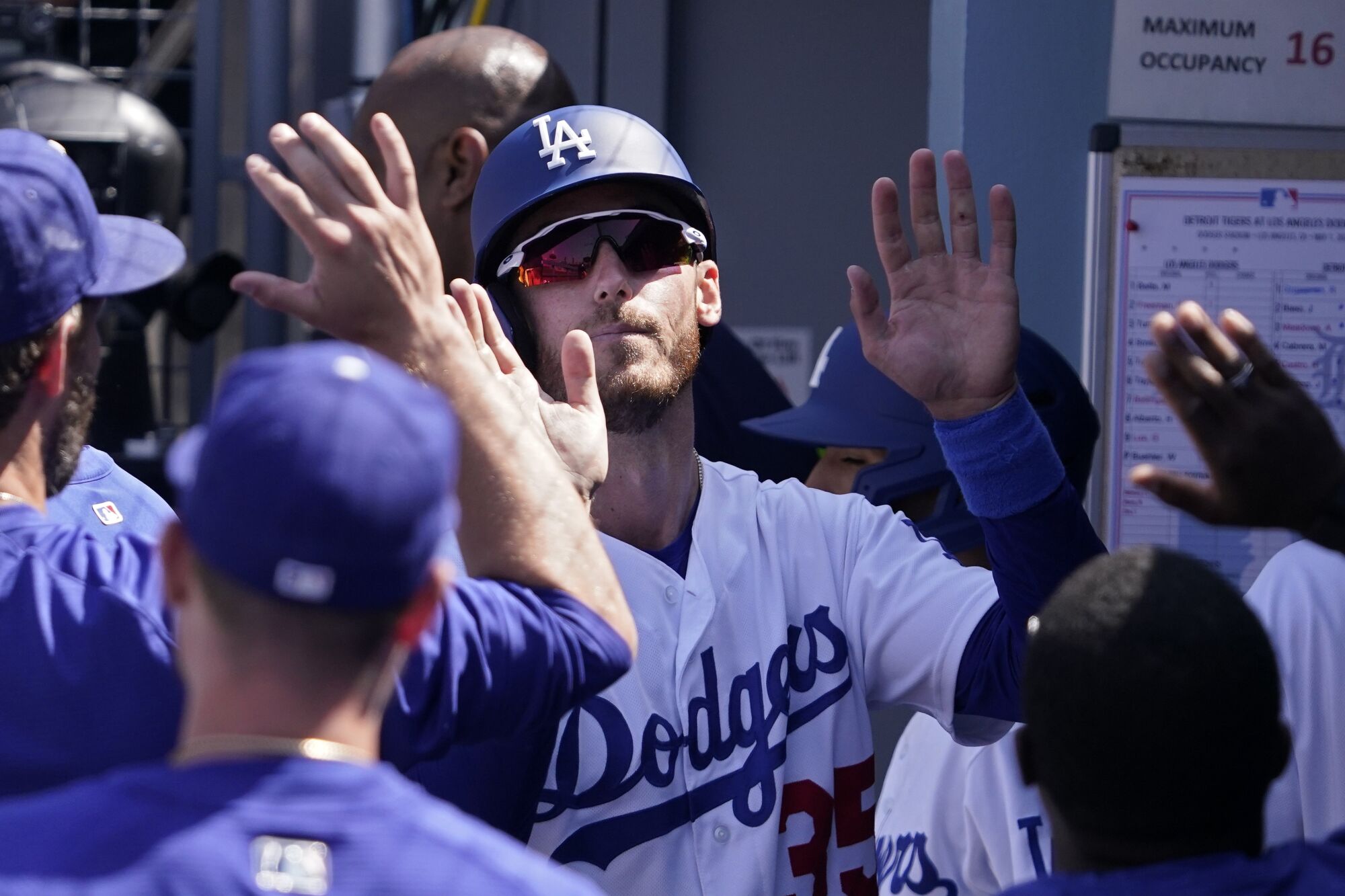 Los Angeles Dodgers' Cody Bellinger is congratulated by teammates in the dugout.