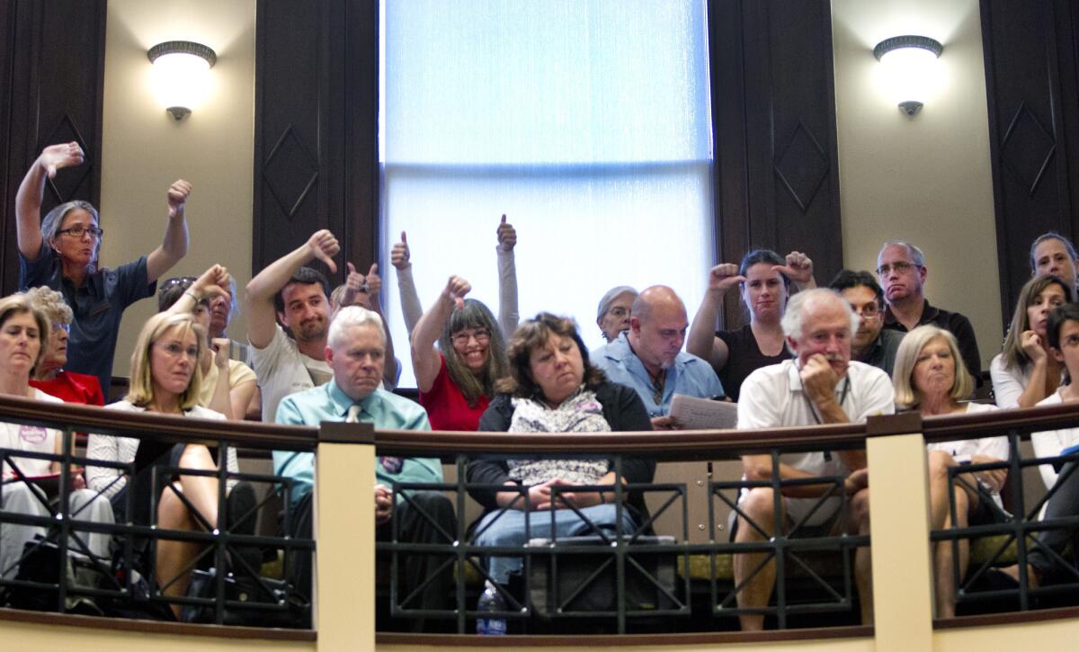 Fluoride opponents and proponents gesture during a Portland City Council meeting in 2012.