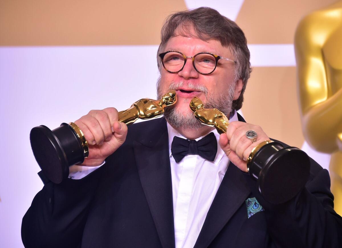 Director Guillermo del Toro poses in the press room with the Oscars for best picture and best director during the 90th Annual Academy Awards on March 4, 2018, in Hollywood, California.