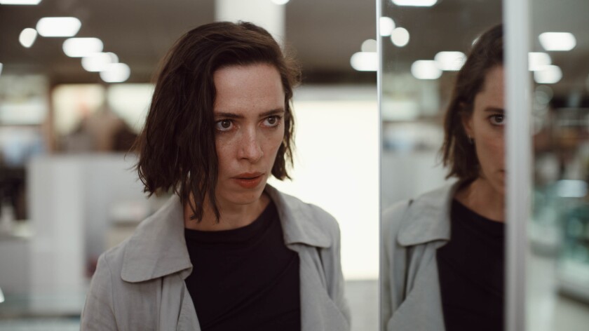 A woman and her reflection both have a frightened expression.