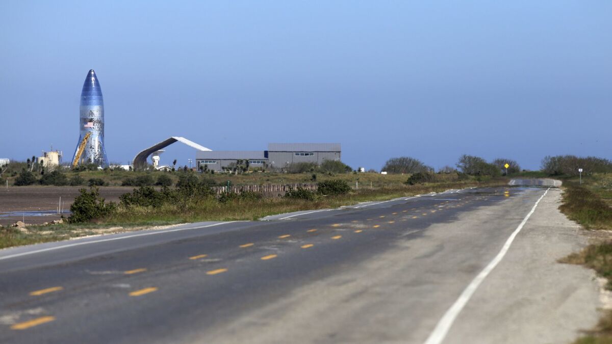 A SpaceX prototype Starship hopper, left, rises at Boca Chica Beach, Texas, on Jan. 12 along Texas Highway 4.