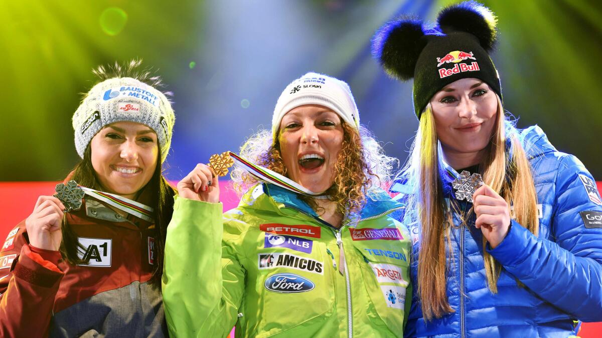 Women's downhill champion Ilka Stuhec is flanked by runner-up Stephanie Venier,, left, and thrid-placer Lindsey Vonn on the podium.