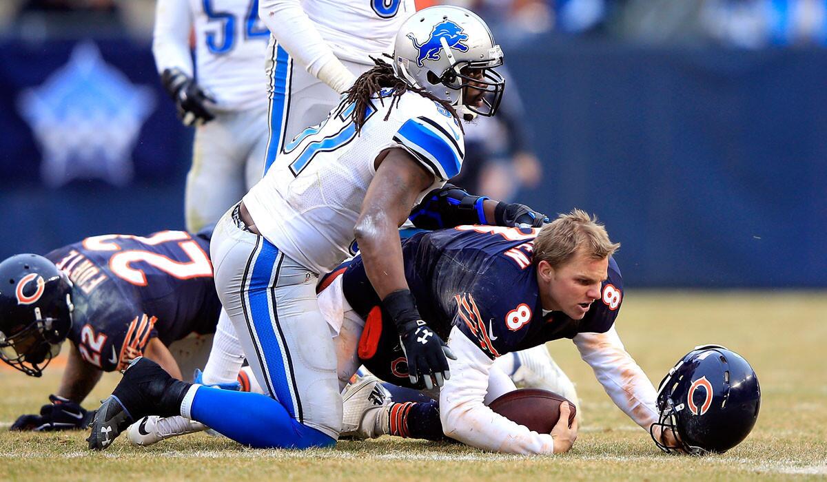 Bears quarterback Jimmy Clausen removes his helmet after taking a head-to-head hit from Lions defensive end Ezekiel Ansah in the fourth quarter Sunday.