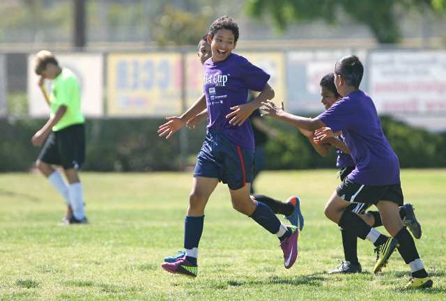 Whittier's Raul Guerrero celebrates with teammates after scoring a goal to tie the game.