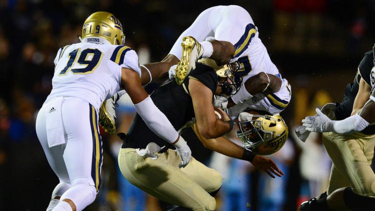 UCLA defensive back Tahaan Goodman flips as he tries to bring down Colorado quarterback Sefo Liufau. To see more images from the game, click on the photo.