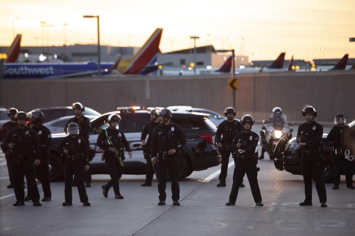 Police work to corral a group protesting outside LAX on Friday.