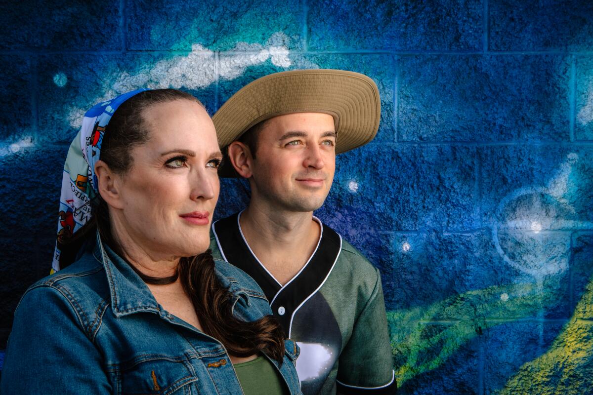 Two people pictured against a galaxy backdrop.