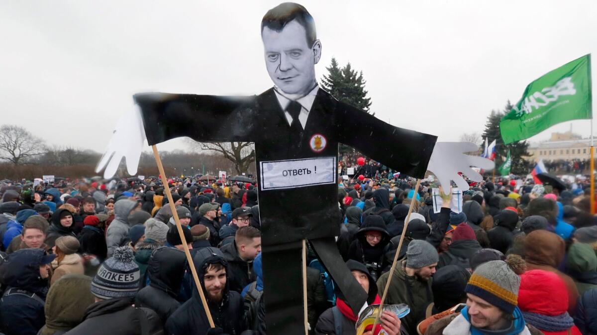 People hold a cardboard figure depicting Russian Prime Minister Dmitry Medvedev with the word "Answer" across his chest during an opposition rally in St. Petersburg, Russia, on March 26, 2017. (Anatoly Maltsev / European Pressphoto Agency)