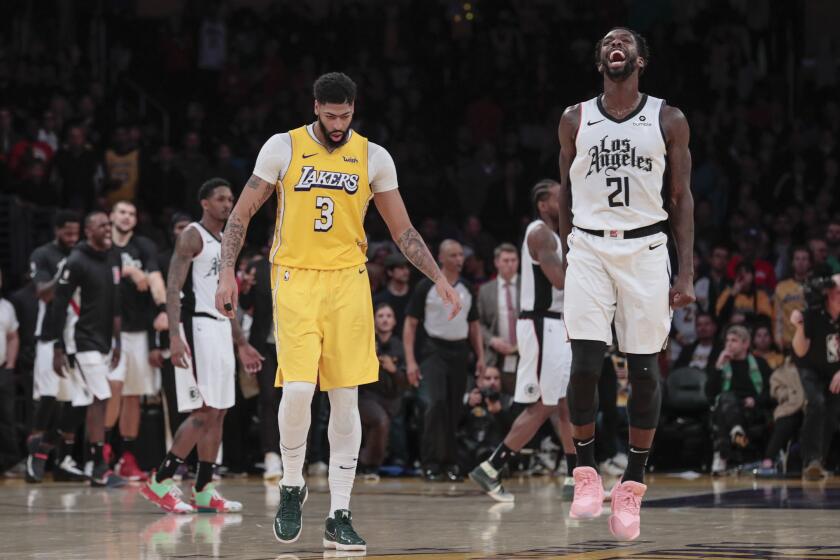 Clippers guard Patrick Beverley (21) celebrates a 111-106 win after Lakers forward Anthony Davis (3) missed an inconsequential shot at the buzzer on Dec. 25, 2019.